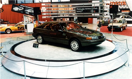 Based on the production Mustang, a four-wheel-drive Ghia Vignale concept car sits on a raised round platform at Ford's main-floor display space (1985 Chicago Auto Show)