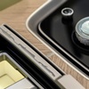 Close up view of the crystal multi-functional controller with Cadillac Goddess emblem in the Cadillac SOLLEI and front console cupholder door accent featuring Cadillac’s historical vehicle silhouettes